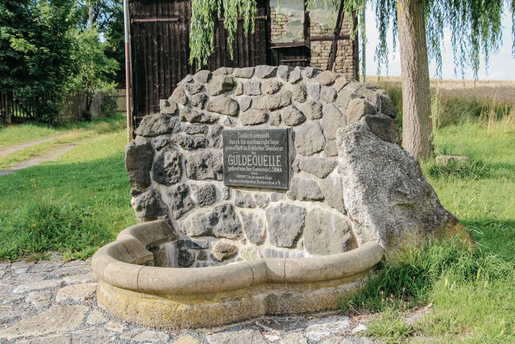 Sehenswürdigkeit Güledequelle mit Bäumen und Hütte im Hintergrund.