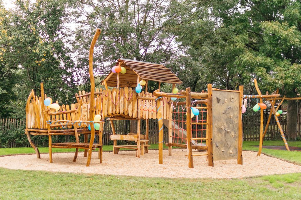 Spielplatz mit Klettergerüst, Rutsche und Schaukel