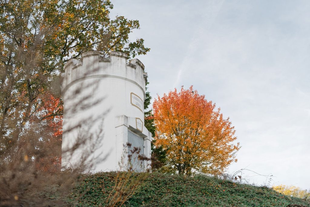 Wasserturm Löhma mit Baum im Hintergrund, das Laub ist orange gefärbt.